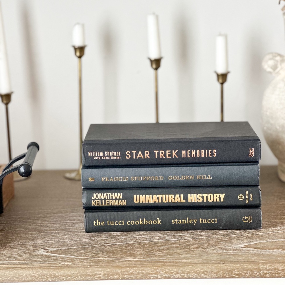 Stack of four black styling books